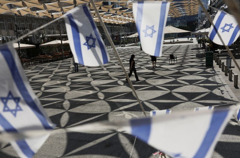 © Reuters. People walk at a square where Israeli flags are displayed, amid the ongoing conflict between Hamas and Israel, in Tel Aviv, Israel, July 16, 2024. REUTERS/Ricardo Moraes/File Photo