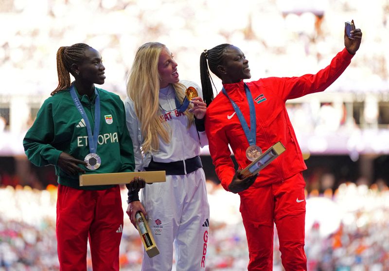 &copy; Reuters. Britânica Keely Hodgkinson,medalha de ouro nos 800 metros nos Jogos Paris 2024, ao lado da medalhista de prata Tsige Duguma, da Etiópia, e da vencedora do bronze, Mary Moraa, do Quênia, posam para selfie no pódion06/08/2024 REUTERS/Aleksandra Szmigiel