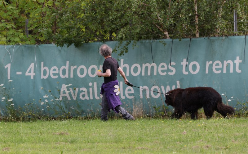 &copy; Reuters. FILE PHOTO: A person walks his dog past a new housing development in Aldershot, Britain, August 4, 2024. REUTERS/Suzanne Plunkett/File Photo