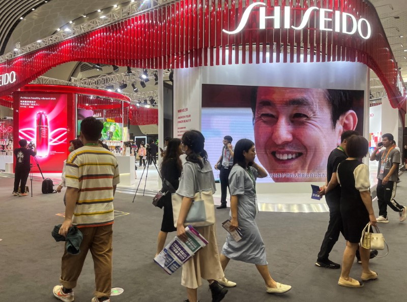 &copy; Reuters. FILE PHOTO: People walk past a booth of Japanese cosmetic brand Shiseido at the third China International Consumer Products Expo, in Haikou, Hainan province, China April 11, 2023. REUTERS/Casey Hall/File Photo