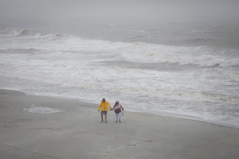 &copy; Reuters. People walk on the beach as Tropical Storm Debby drifts in the East Coast, in Surfside Beach, South Carolina, U.S., August 7, 2024. REUTERS/Marco Bello