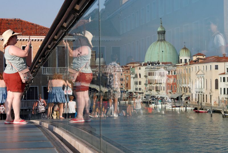 &copy; Reuters. FILE PHOTO: A woman takes a picture from Ponte della Costituzione (Constitution Bridge) in Venice, Italy, September 6, 2020. REUTERS/Yara Nardi/File Photo