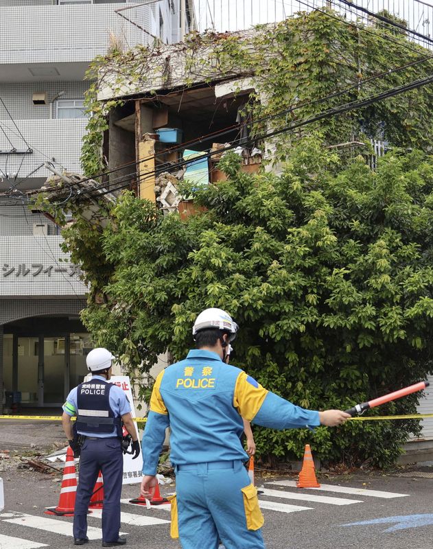 &copy; Reuters. Agenti di polizia sorvegliano un edificio danneggiato da un terremoto a Miyazaki, nel Giappone sud-occidentale, l'8 agosto 2024, in questa foto scattata da Kyodo. Credito obbligatorio Kyodo/via REUTERS