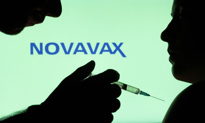 &copy; Reuters. People pose with syringe with needle in front of displayed Novavax logo in this illustration taken, December 11, 2021. REUTERS/Dado Ruvic/Illustration/File Photo