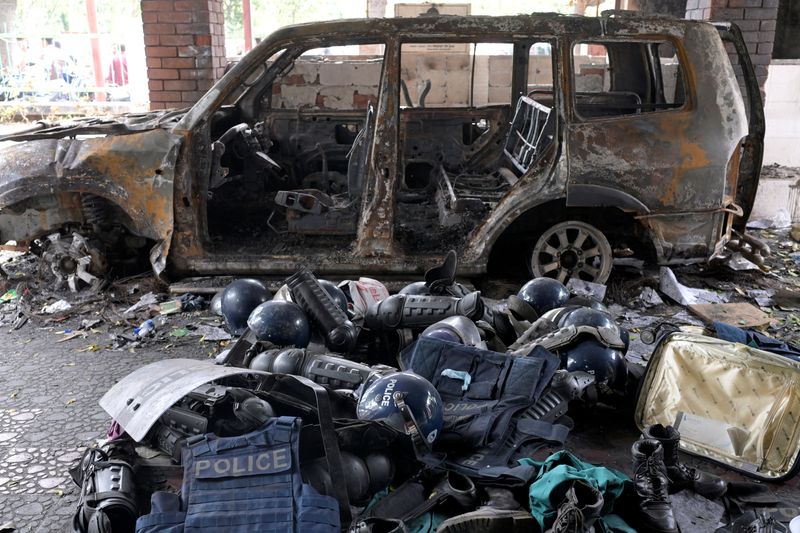 © Reuters. Damaged riot gear of security forces is seen next to a burnt vehicle outside a police station, days after the resignation of former Bangladeshi Prime Minister Sheikh Hasina, in Dhaka, Bangladesh, August 8, 2024. REUTERS/Fatima Tuj Johora