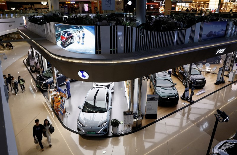 © Reuters. FILE PHOTO: Electric vehicle (EV) models are displayed at the booths of Denza, a joint venture between Mercedes-Benz Group AG and BYD Auto, and Chinese EV maker Voyah, at a shopping mall in Beijing, China November 3, 2023. REUTERS/Tingshu Wang/File Photo