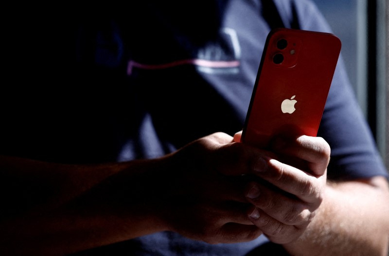 &copy; Reuters. FILE PHOTO: A man poses with an Apple iPhone 12 in a mobile phone store in Nantes, France, September 13, 2023. REUTERS/Stephane Mahe/File Photo