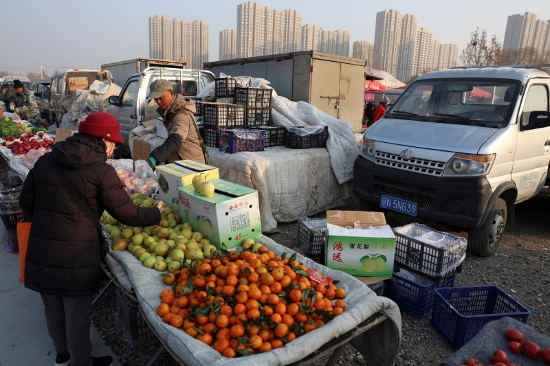 © Reuters. A fruit vendor attends to a customer at an outdoor market in Beijing, China January 12, 2024. REUTERS/Florence Lo/File Photo