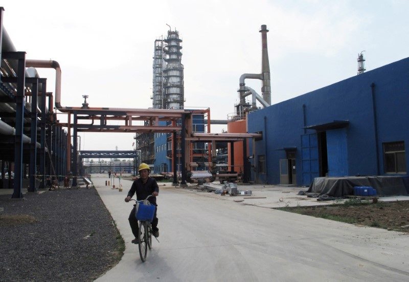 &copy; Reuters. FILE PHOTO: An employee rides a bike on a road near refinery plants of Chambroad Petrochemicals, in Boxing, Shandong Province, China, May 10, 2016. REUTERS/Meng Meng/File Photo