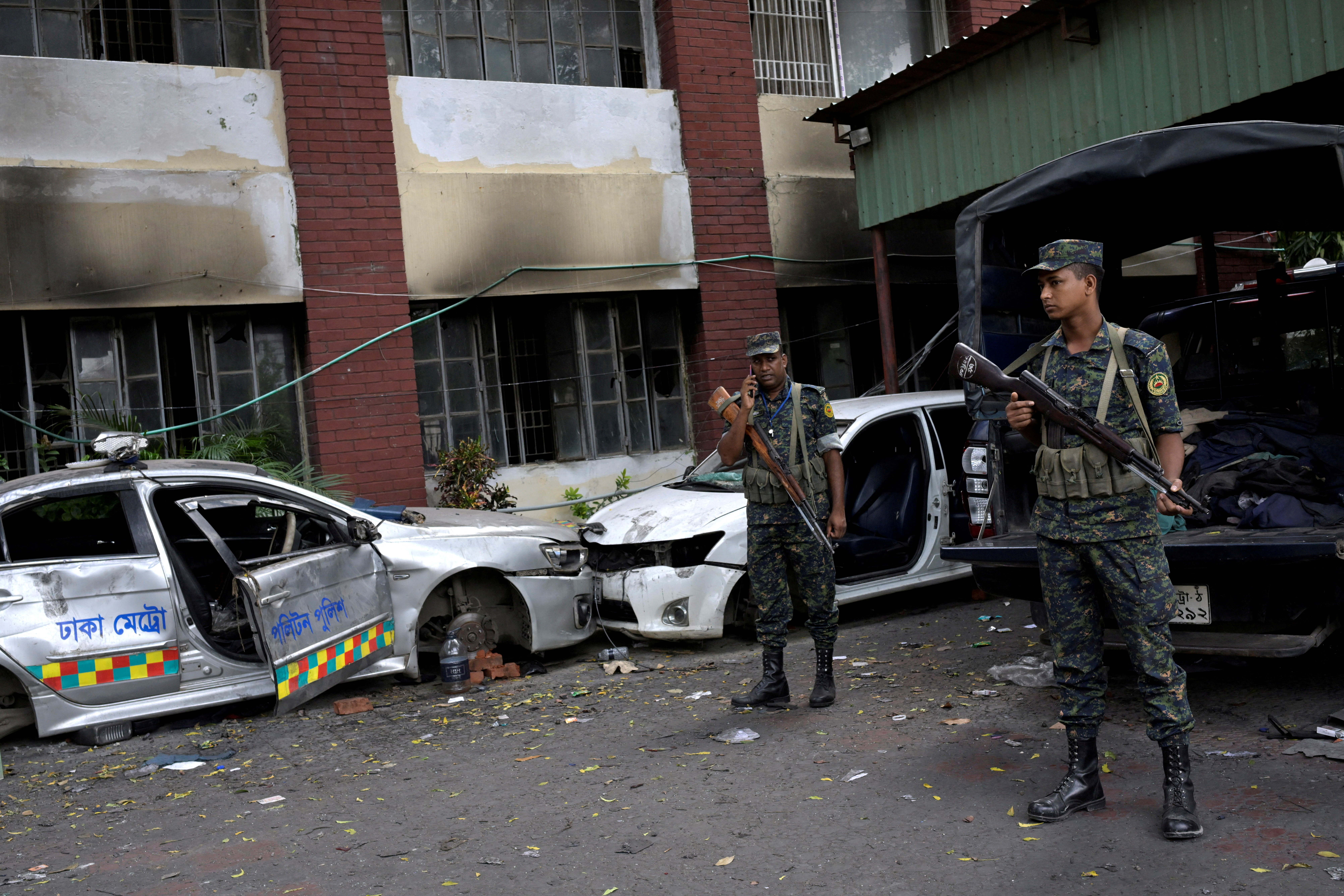 &copy; Reuters. Security force personnel stand guard next to damaged vehicles outside a police station, days after the resignation of former Bangladeshi Prime Minister Sheikh Hasina, in Dhaka, Bangladesh, August 8, 2024. REUTERS/Fatima Tuj Johora   