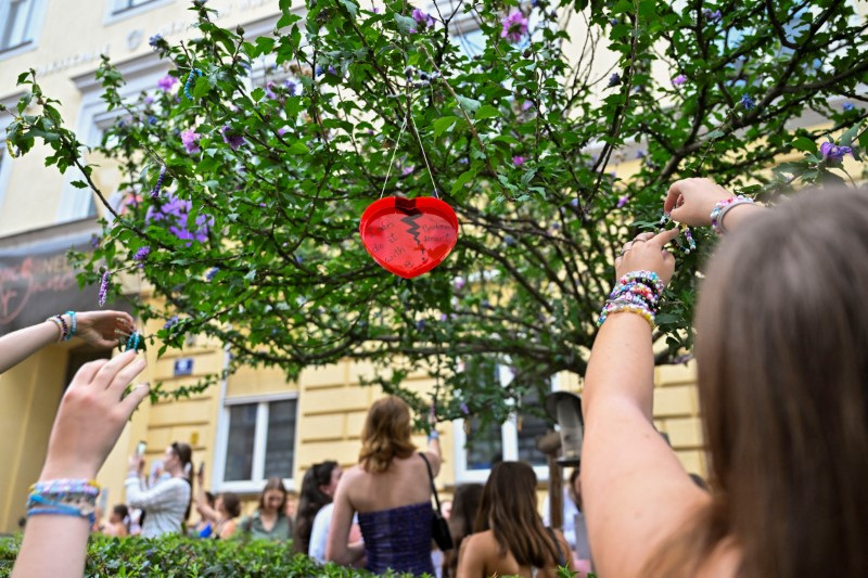 © Reuters. Fans of the singer Taylor Swift leave bracelets on a tree and collect others as they gather following the cancellation of three Taylor Swift concerts at Happel stadium after the government confirmed a planned attack at the venue, in Vienna, Austria August 8, 2024. REUTERS/Elisabeth Mandl