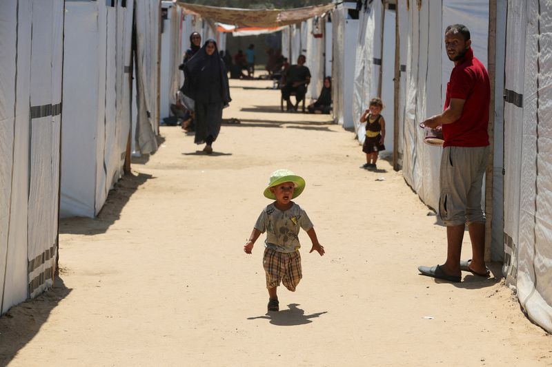 © Reuters. A displaced Palestinian boy runs in a tent camp designated for people with special needs, amid the Israel-Hamas conflict, in Deir Al-Balah in the central Gaza Strip August 8, 2024. REUTERS/Hatem Khaled.