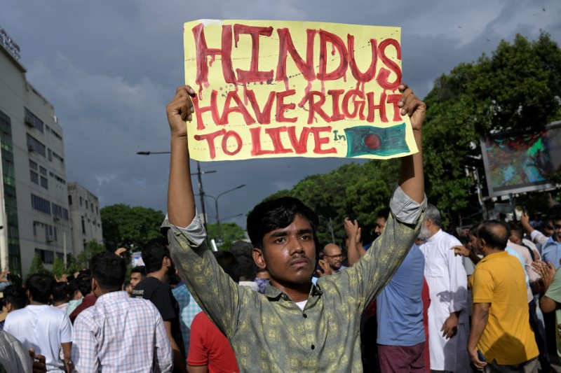 &copy; Reuters. A demonstrator displays a placard during a protest against what they say violence against Hindu communities during ongoing unrest, in Dhaka, Bangladesh, August 9, 2024. REUTERS/Fatima Tuj Johora