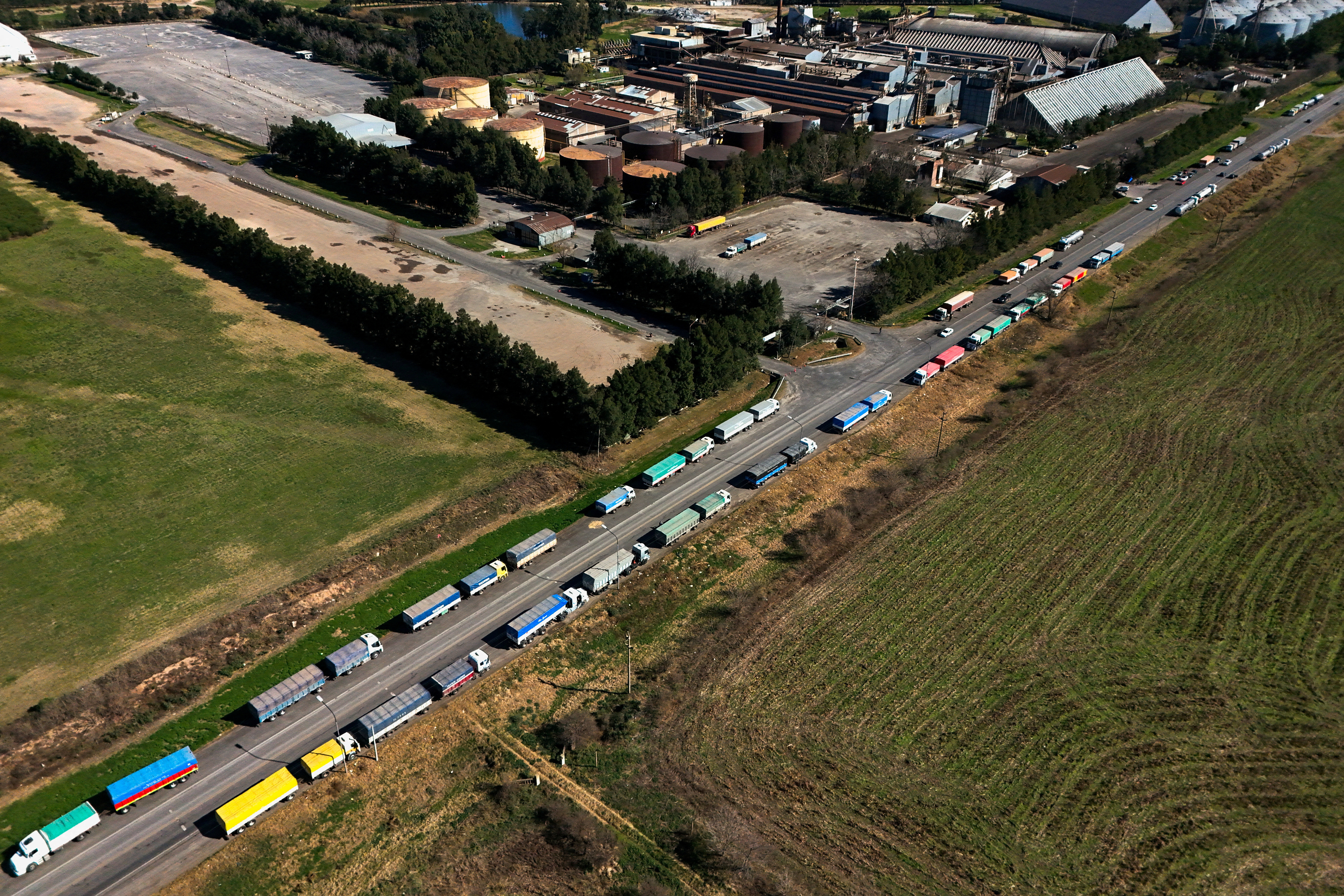 ©Reuters. FILE PHOTO: A drone shot shows trucks used to transport grains parked on the side of a road as a strike by oilseed workers hits terminals, in Rosario, Argentina, August 9, 2024. REUTERS/Matias Baglietto/File Photo