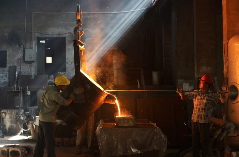 &copy; Reuters. FILE PHOTO: Workers pour molten iron into a mould at a workshop in Hangzhou, Jiangsu province, China July 24, 2019. REUTERS/Stringer/File Photo