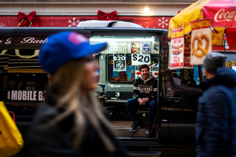 &copy; Reuters. An independent barber waits for customers on his van in a local street in New York, U.S., December 25, 2023. REUTERS/Eduardo Munoz/File Photo