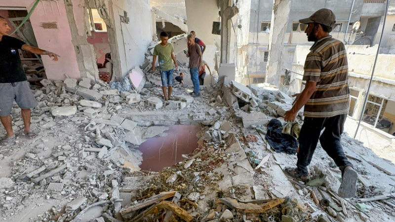 © Reuters. Palestinians inspect the site of an Israeli strike on a house, amid Israel-Hamas conflict, in Gaza City August 12, 2024. REUTERS/Ayman Al Hassi