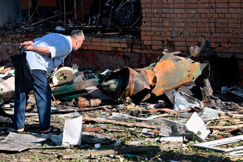 © Reuters. A man looks at debris near a multi-storey residential building, which according to local authorities was hit by remains of a destroyed Ukrainian missile, in the course of Russia-Ukraine conflict in Kursk, Russia August 11, 2024. Kommersant Photo/Anatoliy Zhdanov via REUTERS  