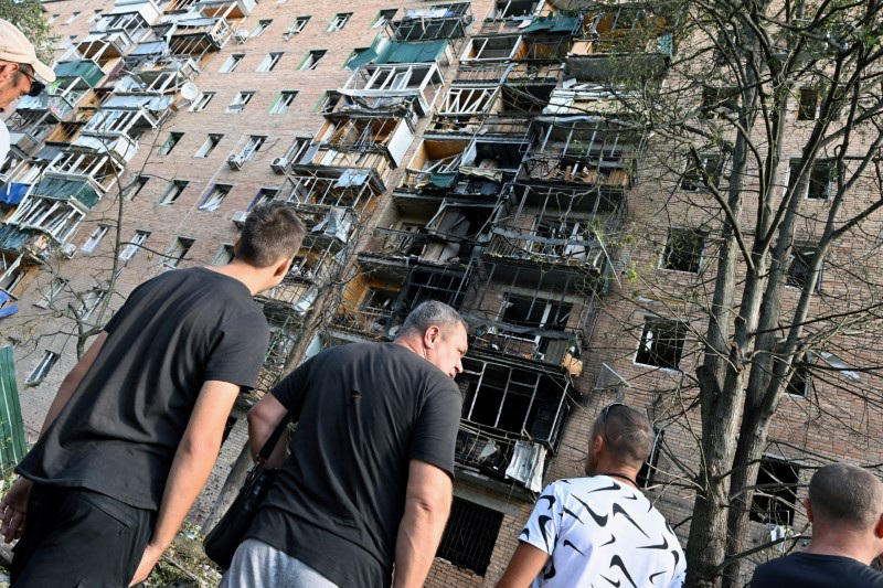 © Reuters. People gather in the courtyard of a multi-storey residential building, which according to local authorities was hit by debris from a destroyed Ukrainian missile, in the course of Russia-Ukraine conflict in Kursk, Russia August 11, 2024. Kommersant Photo/Anatoliy Zhdanov via REUTERS 