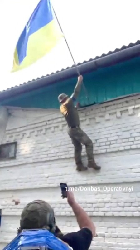 © Reuters. A Ukrainian soldier raises a Ukrainian flag in Guevo, Kursk Oblast, Russia released August 11, 2024  in this still image obtained from a social media video. Donbas_Operativnyi via Telegram/via REUTERS 