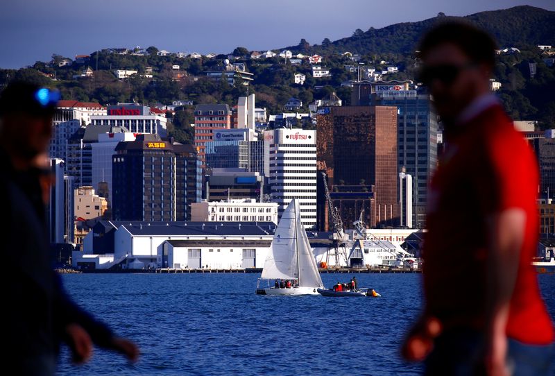 © Reuters. FILE PHOTO: Pedestrians walk past a sailing boat as it passes in front of the central business district (CBD) of Wellington in New Zealand, July 2, 2017. REUTERS/David Gray/File photo