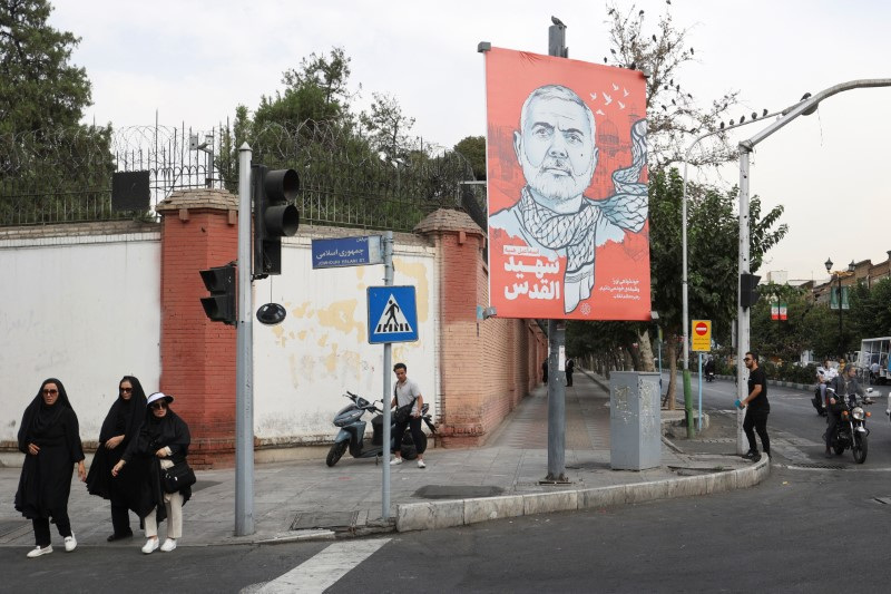 © Reuters. People walk past a banner with a picture of late Hamas leader Ismail Haniyeh in a street in Tehran, Iran, August 12, 2024. Majid Asgaripour/WANA (West Asia News Agency) via REUTERS   