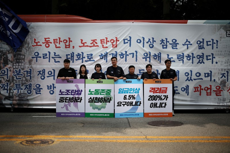 &copy; Reuters. FILE PHOTO: Members of National Samsung Electronics Union hold placards bearing their messages against the company in front of the company building while staging a walkout protest, in Seoul, South Korea, June 7, 2024.    REUTERS/Kim Hong-Ji/File Photo