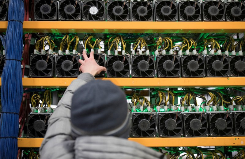 &copy; Reuters. A worker checks the fan on a miner, at the cryptocurrency farming operation, Bitfarms, in Farnham, Quebec, Canada, February 2, 2018. Picture taken February 2, 2018. REUTERS/Christinne Muschi/File Photo