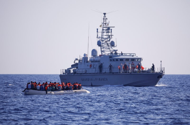 © Reuters. Italian Guardia di Finanza patrol vessel arrives to take onboard the migrants, who are in a rubber boat to take them to Lampedusa near NGO Open Arms rescue boat Astral in international waters south of Lampedusa, in the central Mediterranean Sea, August 13, 2024. REUTERS/Juan Medina