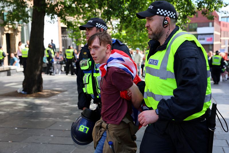 © Reuters. FILE PHOTO: An anti-immigration protester is detained by police officers, in Newcastle, Britain August 10, 2024. REUTERS/Denis Balibouse/File Photo