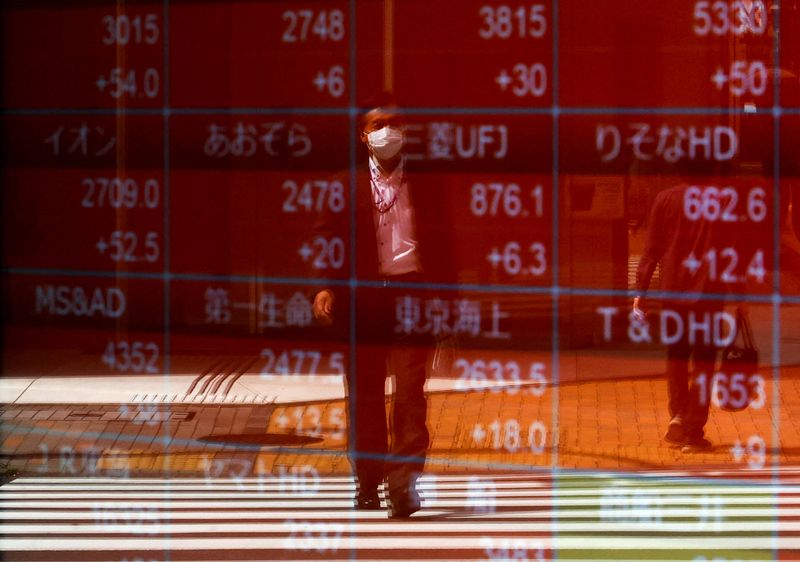 © Reuters. FILE PHOTO: A man is reflected on an electric stock quote board outside a brokerage exchange in Tokyo, Japan, April 18, 2023. REUTERS/Issei Kato/File Photo