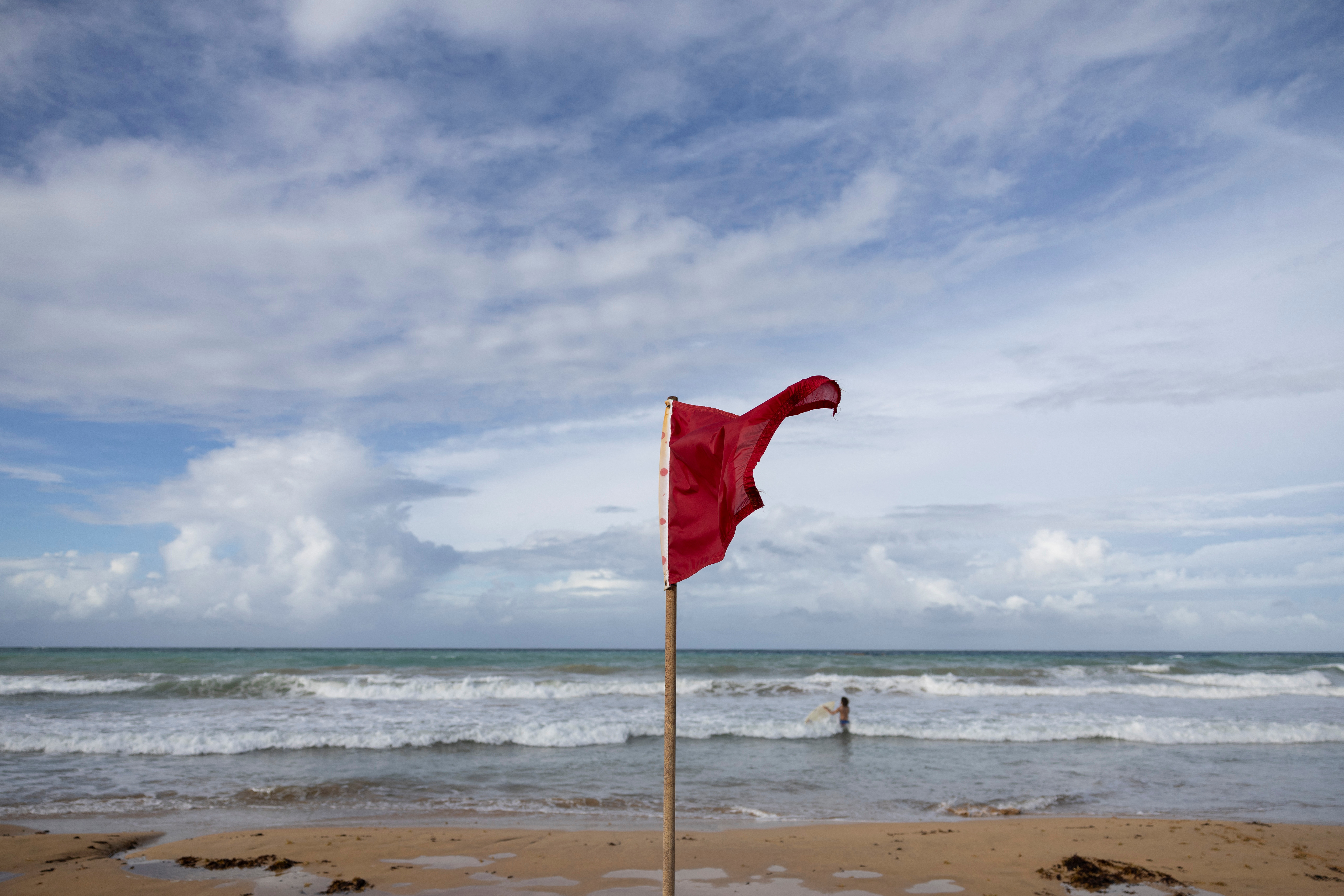 © Reuters. A red flag indicating strong currents waves in La Pared Beach as Tropical Storm Ernesto approaches, in Luquillo, Puerto Rico August 13, 2024.  REUTERS/Ricardo Arduengo