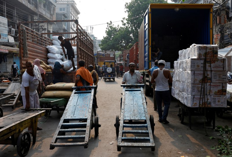 © Reuters. FILE PHOTO: Labourers unload spices and dry fruits from supply trucks at a wholesale market in the old quarters of Delhi, India, July 22, 2024. REUTERS/Priyanshu Singh/File Photo