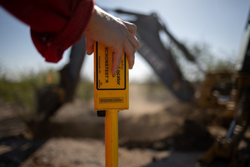 &copy; Reuters. Sarah Stogner, an oil and gas lawyer, holds a metal detector in front of a backhoe which uncovers an abandoned well in Pecos County, Texas, U.S., August 6, 2024. REUTERS/Adrees Latif