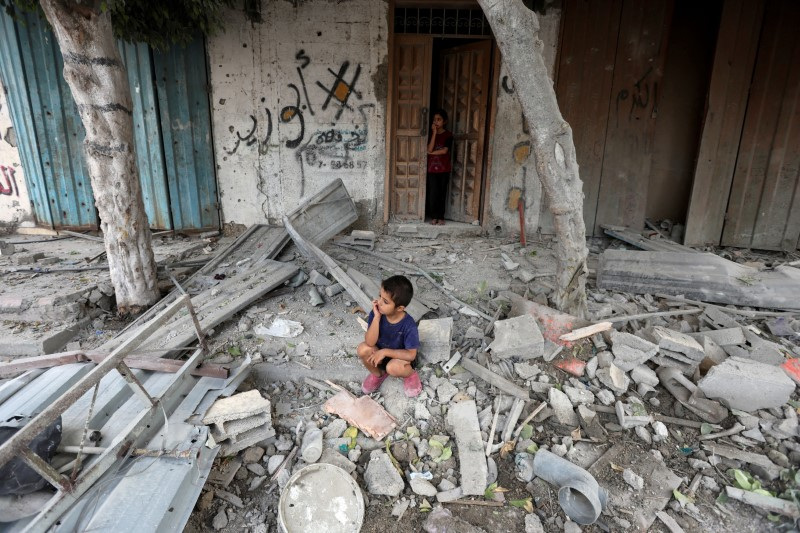 &copy; Reuters. Un ragazzo palestinese siede sul luogo di un attacco israeliano a una casa, nel corso del conflitto tra Israele e Hamas, nel campo profughi di Maghazi, nella Striscia di Gaza centrale, il 14 agosto 2024. REUTERS/Ramadan Abed