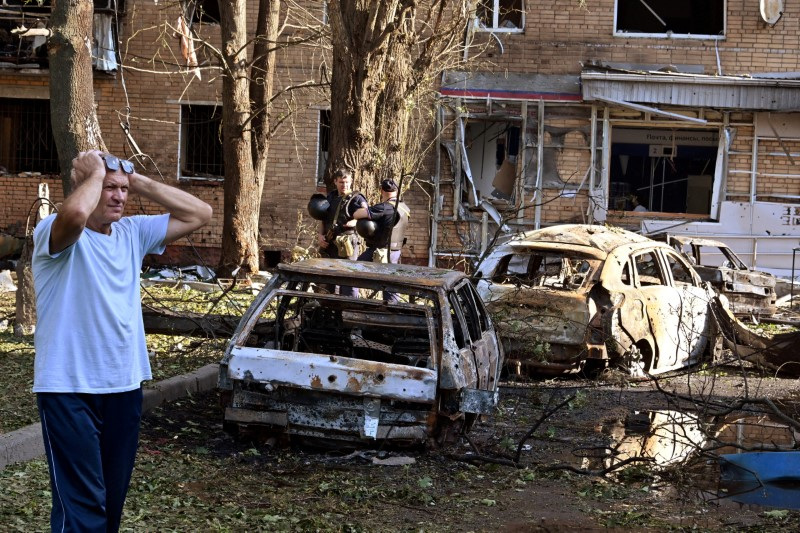 © Reuters. A man reacts while standing next to burnt-out remains of cars in the courtyard of a multi-storey residential building, which according to local authorities was hit by debris from a destroyed Ukrainian missile, in the course of Russia-Ukraine conflict in Kursk, Russia August 11, 2024. Kommersant Photo/Anatoliy Zhdanov via REUTERS/File Photo