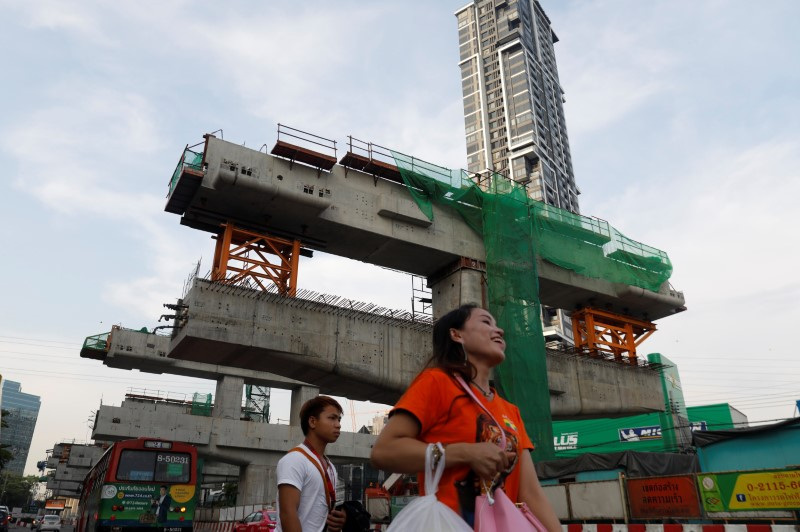 &copy; Reuters. FILE PHOTO: People walk past a Skytrain (Bangkok Mass Transit System) construction site in Bangkok, Thailand May 13, 2018. REUTERS/Soe Zeya Tun/File Photo