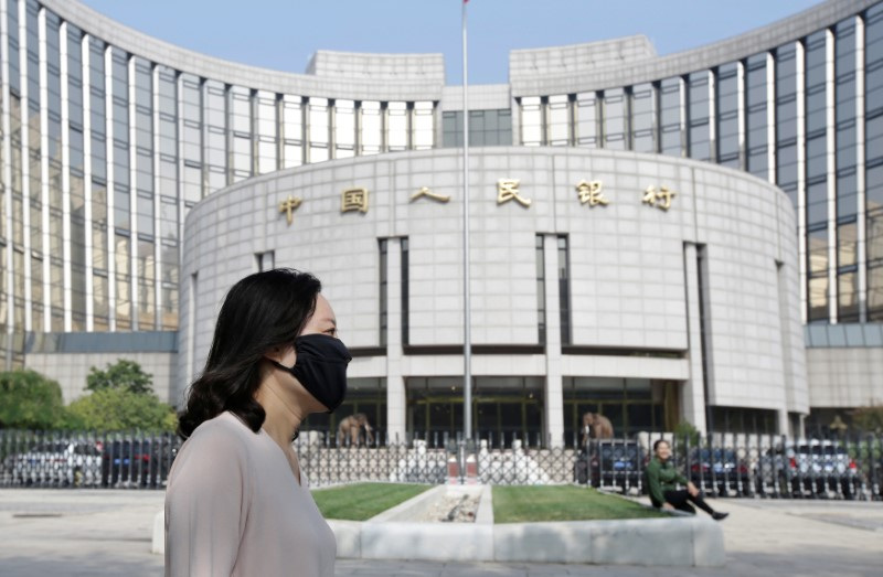 © Reuters. A woman walks past the headquarters of the People's Bank of China (PBOC), the central bank, in Beijing, China September 28, 2018. REUTERS/Jason Lee/ File Photo