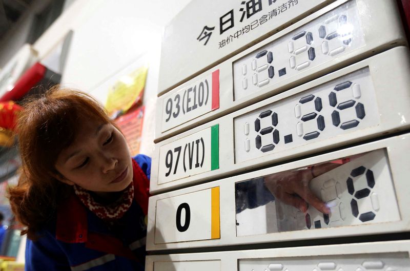 © Reuters. FILE PHOTO: An employee adjusts a diesel price tag on display at a gas station in Rongshui, Guangxi Zhuang Autonomous Region, early March 27, 2014. REUTERS/Stringer/ File Photo