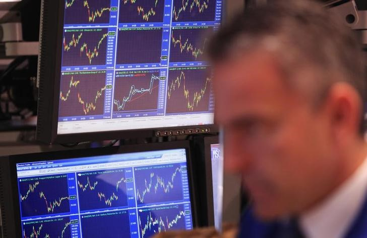 © Reuters. FILE PHOTO: Price charts are displayed on a screen behind a trader at the New York Stock Exchange in New York. REUTERS/Lucas Jackson/File Photo