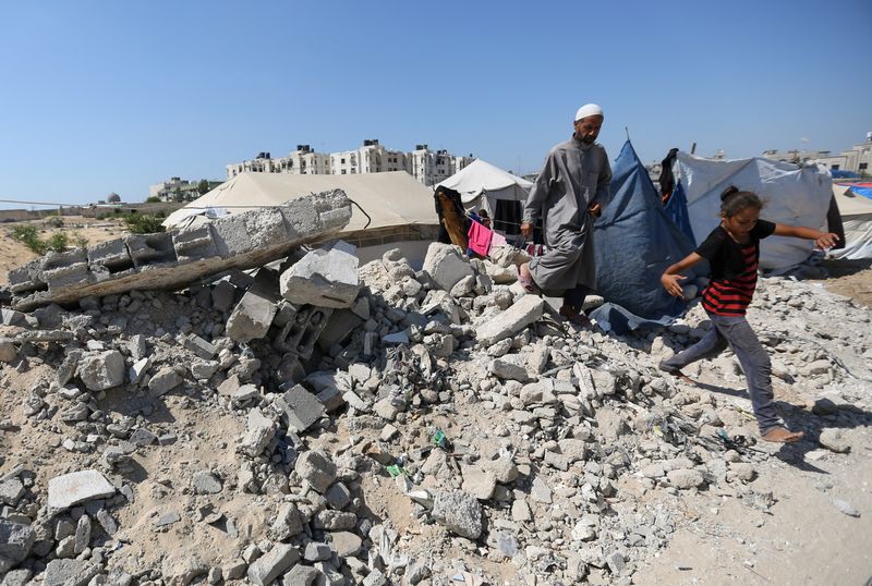 &copy; Reuters. Displaced Palestinians shelter in a cemetery, as Gaza health ministry announced that death toll has surpassed 40,000, amid the Israel-Hamas conflict, in Khan Younis, in the southern Gaza Strip, August 15, 2024. REUTERS/Hatem Khaled