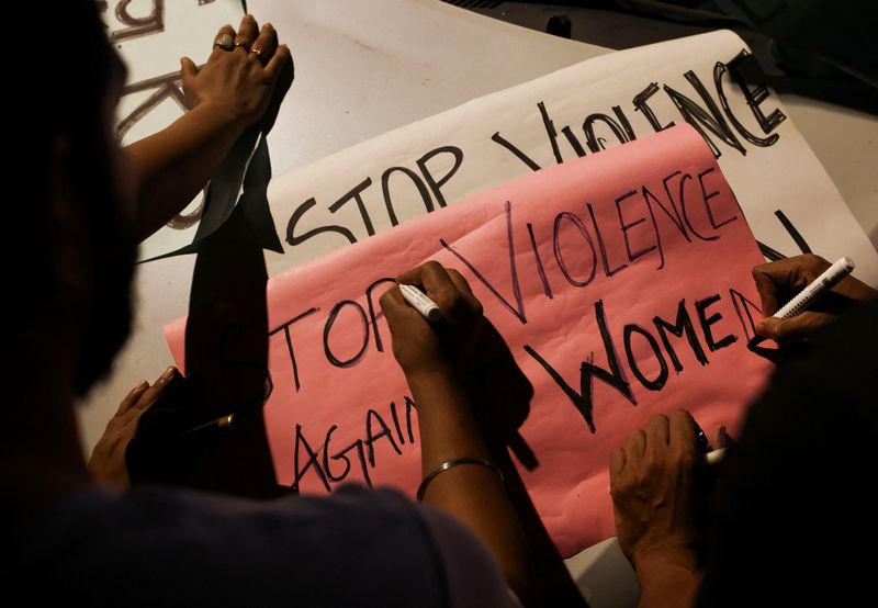 &copy; Reuters. FILE PHOTO: People write slogans on posters before the start of a candlelight vigil condemning the rape and murder of a trainee medic at a government-run hospital in Kolkata, on a street in Mumbai, India, August 14, 2024. REUTERS/Francis Mascarenhas/File 