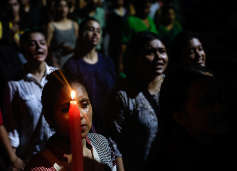 © Reuters. FILE PHOTO: A woman holds a candle as she attends a candlelight vigil held outside Jadavpur University campus, condemning the rape and murder of a trainee medic at a government-run hospital in Kolkata, India, August 15, 2024. REUTERS/Sahiba Chawdhary/File Photo