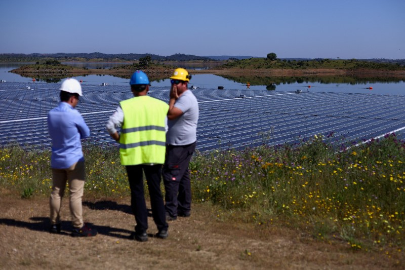 © Reuters. FILE PHOTO: Workers talk during the installation of EDP's (Energias de Portugal) largest floating solar farm on a dam in Europe, on the surface of Alqueva dam, in Moura, Portugal, May 5, 2022. Picture taken May 5, 2022. REUTERS/Pedro Nunes/File Photo