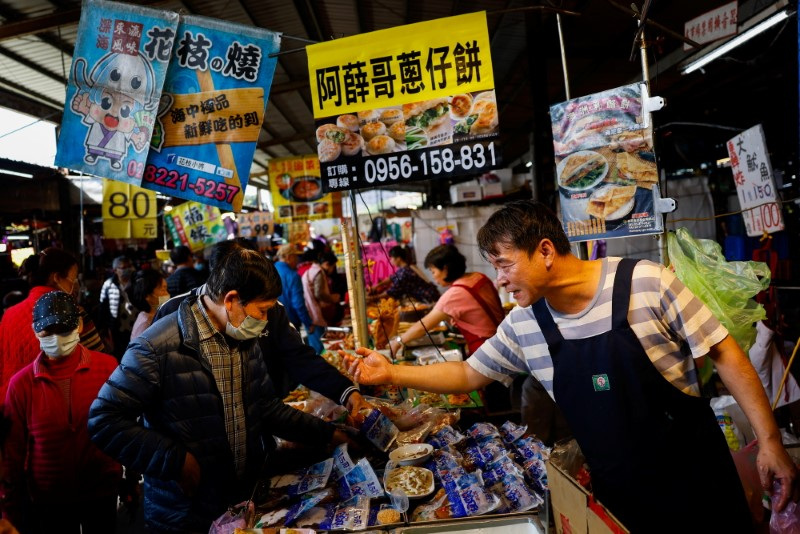 &copy; Reuters. FILE PHOTO: People sell products at their stall at a market in New Taipei City, Taiwan January 31, 2024. REUTERS/Ann Wang/File Photo