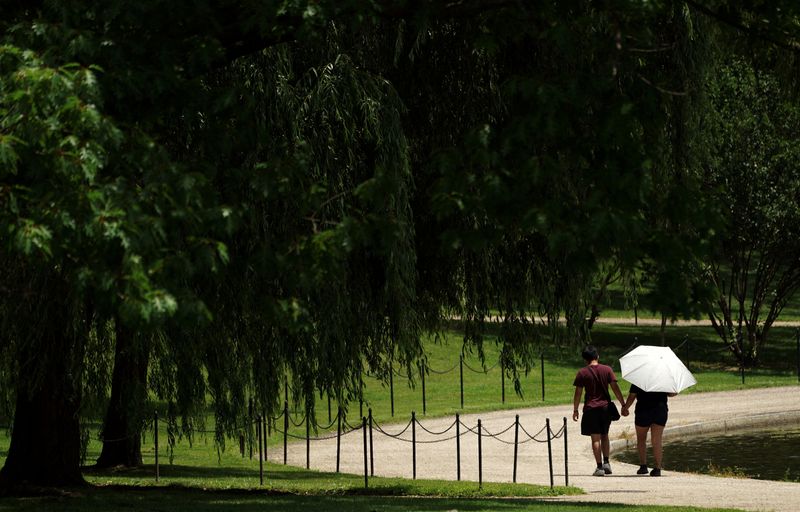 &copy; Reuters. FILE PHOTO: A couple walk hand-in-hand beside a pond on the National Mall in Washington, U.S., May 30, 2024.  REUTERS/Kevin Lamarque/File Photo