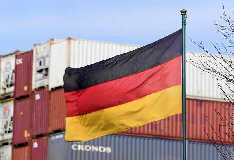 © Reuters. FILE PHOTO: A German flag blows in the wind in front of a stack of containers at the harbour in Hamburg, Germany, February 24, 2022. REUTERS/Fabian Bimmer/File Photo