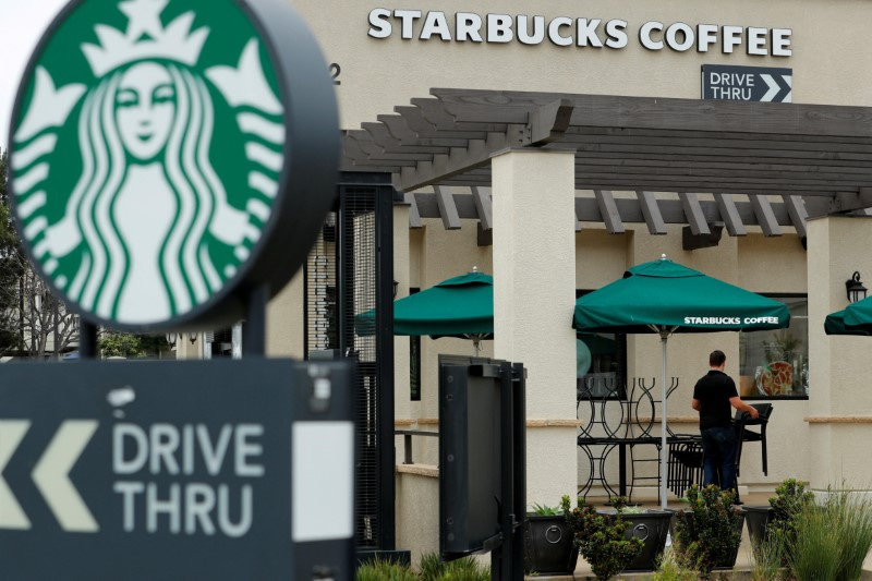 © Reuters. FILE PHOTO: A worker puts away patio furniture at a Starbucks Corp drive-through location in Oceanside, California, U,S. May 29, 2018.    REUTERS/Mike Blake/File Photo