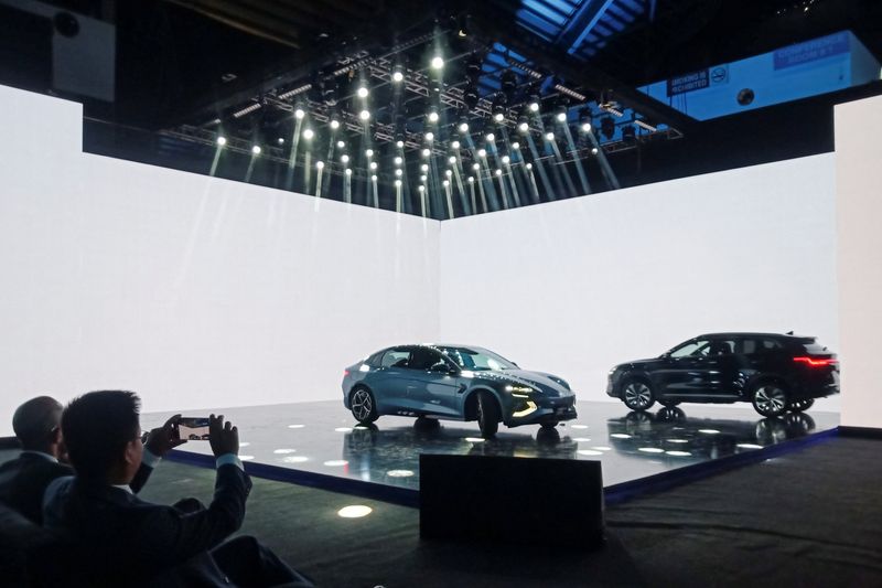 © Reuters. An attendee takes photos of the Chinese electric vehicle BYD models on display, during an event to announce the plans to open a car production plant in Pakistan, in Lahore, Pakistan August 17, 2024. REUTERS/Stringer