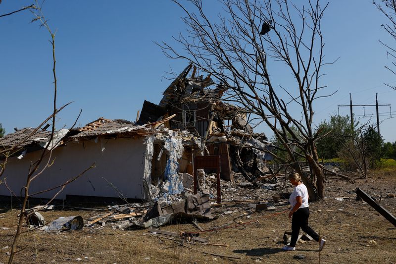 © Reuters. A woman walks with a dog past a residential building damaged during a Russian missile strike, amid Russia's attack on Ukraine, outside of Kyiv, Ukraine August 18, 2024. REUTERS/Valentyn Ogirenko